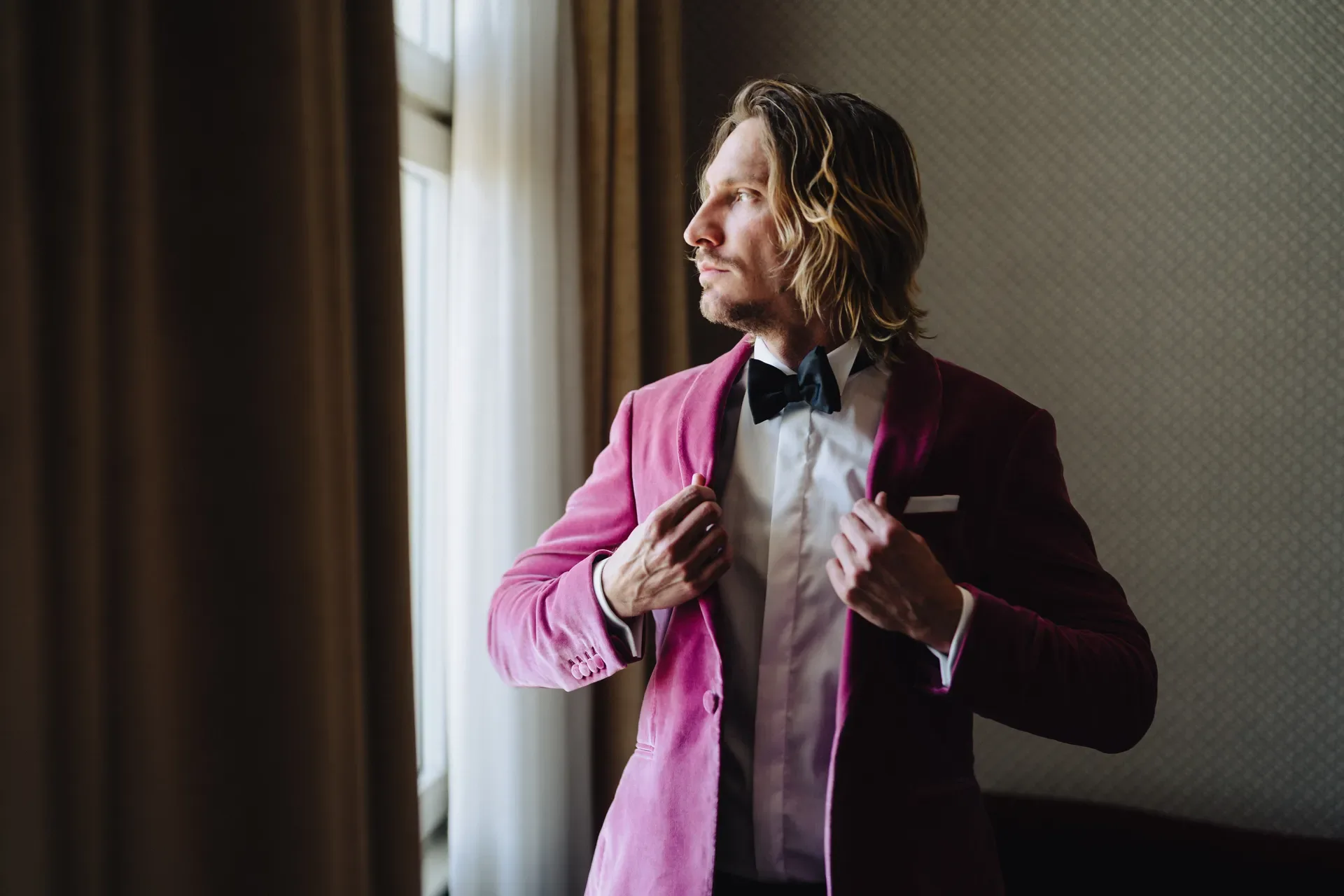 Groom in a magenta velvet jacket getting ready at Soho House Berlin