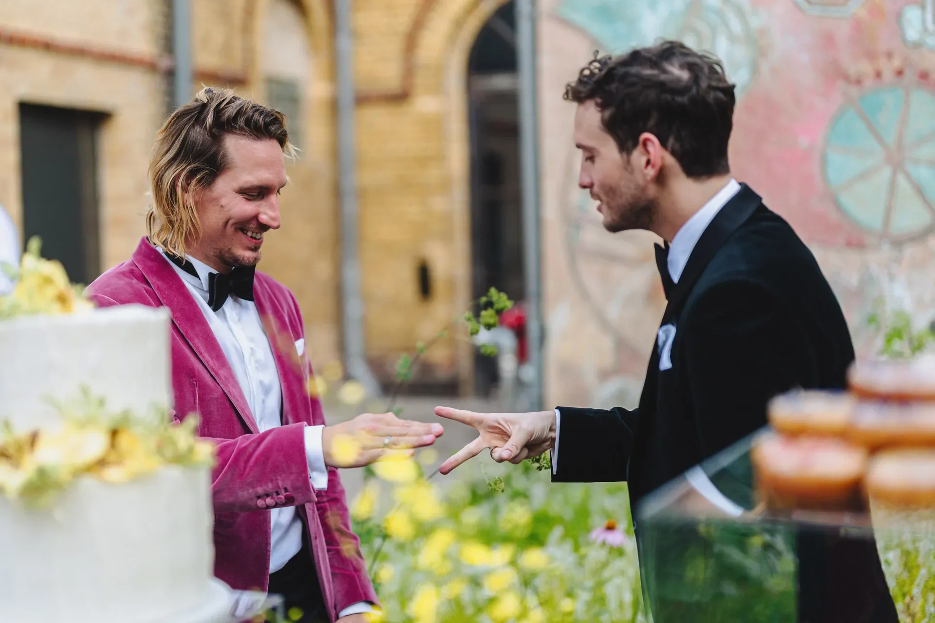 Shaun and Hendrik cutting their wedding cake in the courtyard