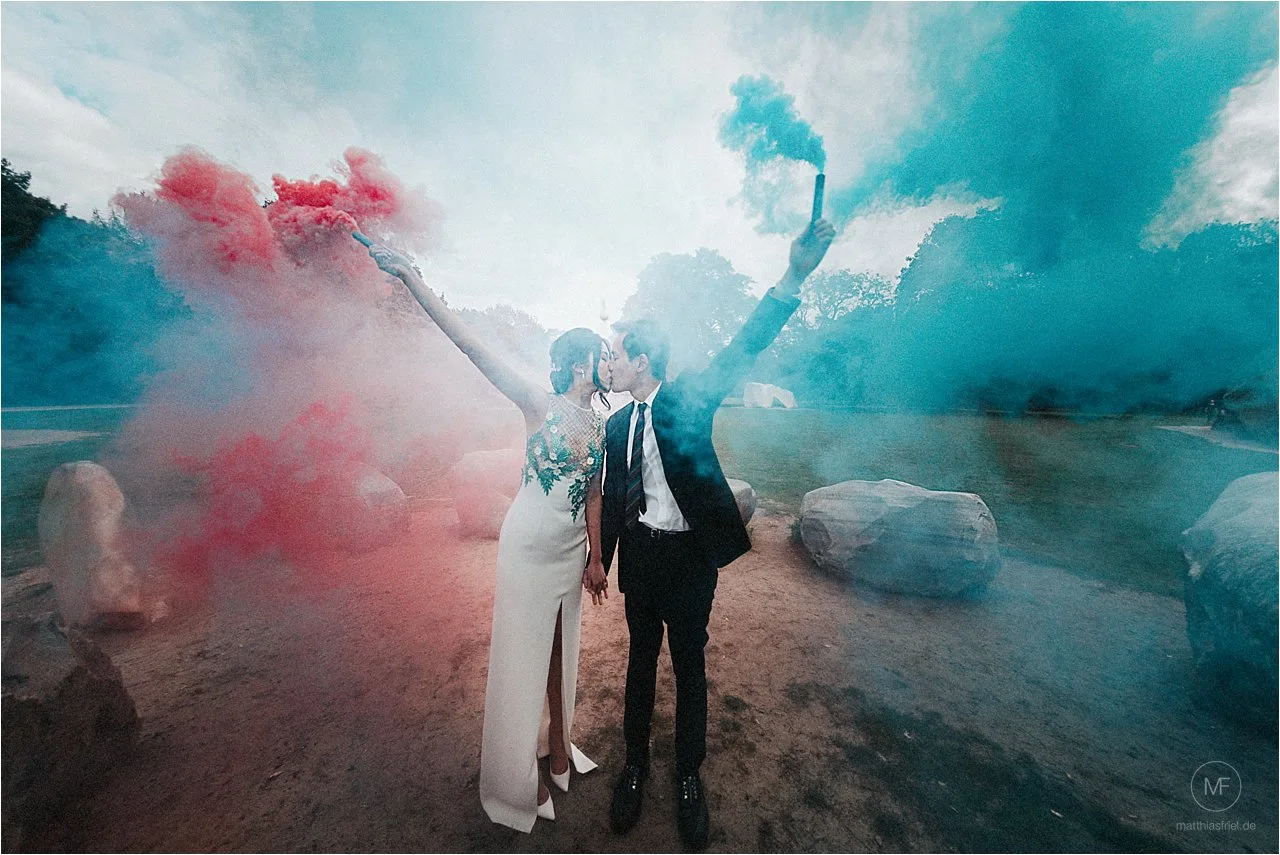 Couple portrait with red and blue colour smoke in the Tiergarten, Berlin